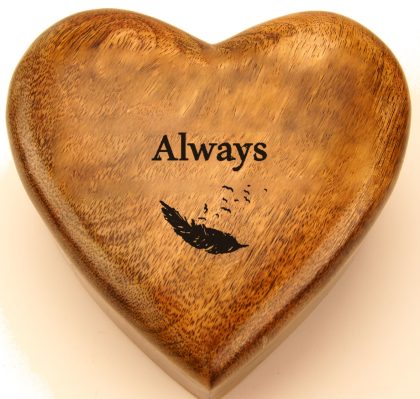 A drifting feather engraved on a mango wood heart urn